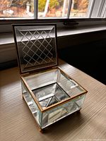 Open cut glass jewelry box showing hinged lid and interior