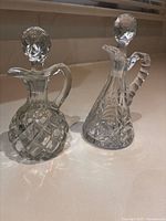 Two cut glass cruets with stoppers side by side