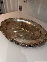 Large silver-plated meat tray showing tree well, gadroon rim