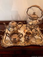 Full view showing all silver-plated pieces on tray: kettle on stand, teapot, sugar bowl, creamer, tray