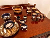 Overall view of all silver-plated cobalt glass condiment pieces on surface