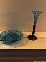 Turquoise pressed glass bowl and matching vase with metal base displayed side by side