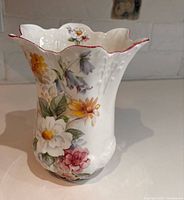 Front view showing floral design, scalloped rim with red edge