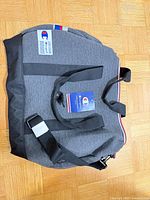 Top view of Champion duffel showing overall shape, handles, shoulder strap and attached hang tag