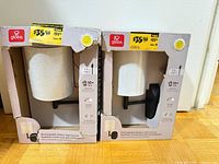 Front view of both boxed lamps showing brand, finish, shade, and quantity