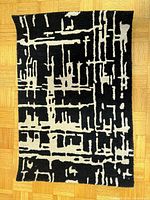 Front view of rectangular black and ivory geometric rug