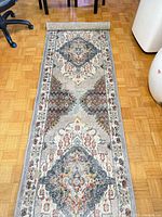 Full length view of Surya runner rug rolled at one end showing overall pattern