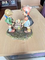 Front view of figurine showing children, cradle, and baby