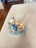Figurine top view showing girl, teddy bear, base