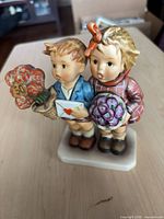 Front view of Goebel Hummel figurine showing children, flowers, envelope