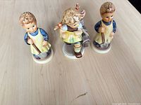 Front view of three Goebel Hummel figurines