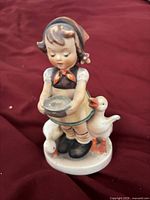 Front view of Goebel Hummel figurine showing girl, bowl, two geese
