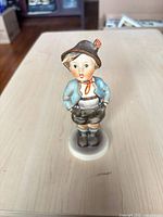 Front view of porcelain boy figurine on base