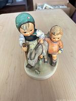 Front view showing full figurine, children, goat, base