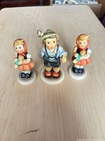 Front view of three Hummel Goebel figurines