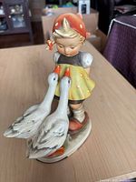 Front view showing full figurine, girl with bonnet and two geese