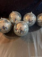 Five mirrored disco balls grouped together