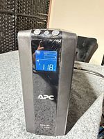 Front view showing APC logo and blue LCD screen displaying input voltage