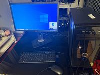 Full setup showing tower, Dell monitor, HP keyboard, mouse with Windows 10 desktop displayed