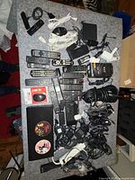 Full lot view showing remotes, Fire TV Stick, boxed adapter, mouse, power strip and numerous cables