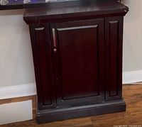 Front view of dark brown wooden cabinet closed