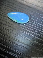 Pear-shaped crystal opal front view showing blue play-of-color