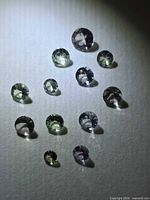 Group of 11 multicolored round-cut tanzanite gemstones under light