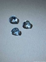 Three heart-cut aquamarines on neutral background