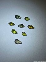 Eight pear-cut green tanzanite gemstones on white background