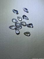 Group of loose pear-cut tanzanite gemstones on grey background