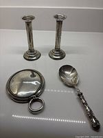 Group shot: hand mirror, berry spoon, pair candlesticks