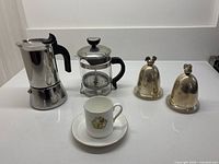 Group shot showing all items: moka pot, French press, demitasse cup and saucer, two lidded egg cups
