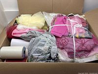 Overview of box showing assorted fabrics tied in bundles and ribbon spools