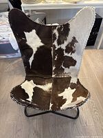 Front view showing faux cowhide upholstery and overall shape