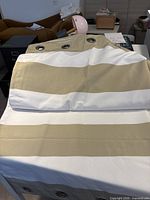 Curtain panels laid out showing taupe and white stripes and grommets