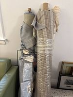 Two fabric bolts standing upright, one wrapped in plastic