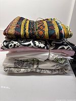 Stacked bundle of six cotton fabrics showing patterns and colours