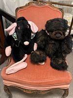 Bear and rat puppets seated on chair