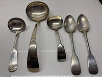 Five pieces of silver plate flatware laid out