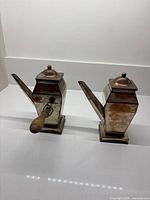 Front view of both copper servers showing shape and spouts