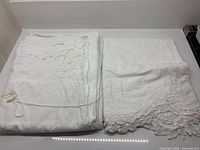 Folded queen sheets with lace detail alongside pillowcases