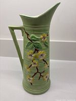 Front view of green Maling Blossom jug showing floral relief and spout