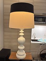 Full view of white ceramic lamp with black and white shade