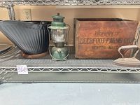 Overview of bucket, lantern, crate, sad iron on shelf