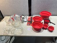 Full lot overview on table showing silicone pieces, glass bakeware, packaged items