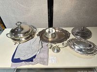 All serveware pieces, candlestick, bowl and cloths on table