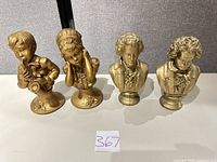 Group view of all four gold resin busts