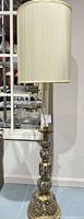 Full view of brass floor lamp with shade