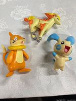Ponyta, Buizel, and Minun figures showing size and wear