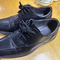 Pair of black leather lace-up Soft Stags shoes on table